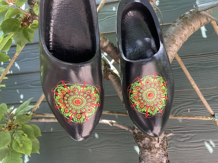 Twee zwarte klompen met een mandala in rood en limoengroen