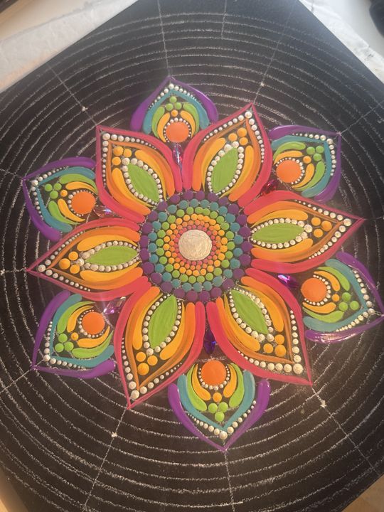 Grote mandala in oranje, groen en paars op zwart, met de potloodhulplijnen nog zichtbaar